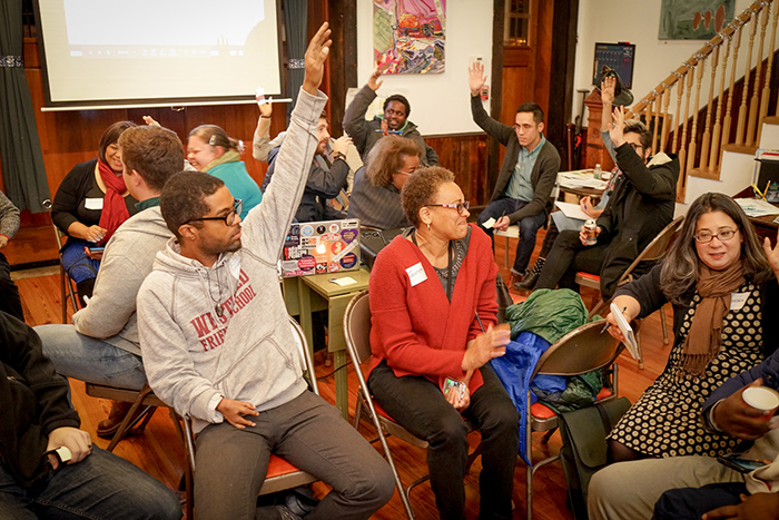 Group of people in Camden, N.J., raising hands in response to a question.
